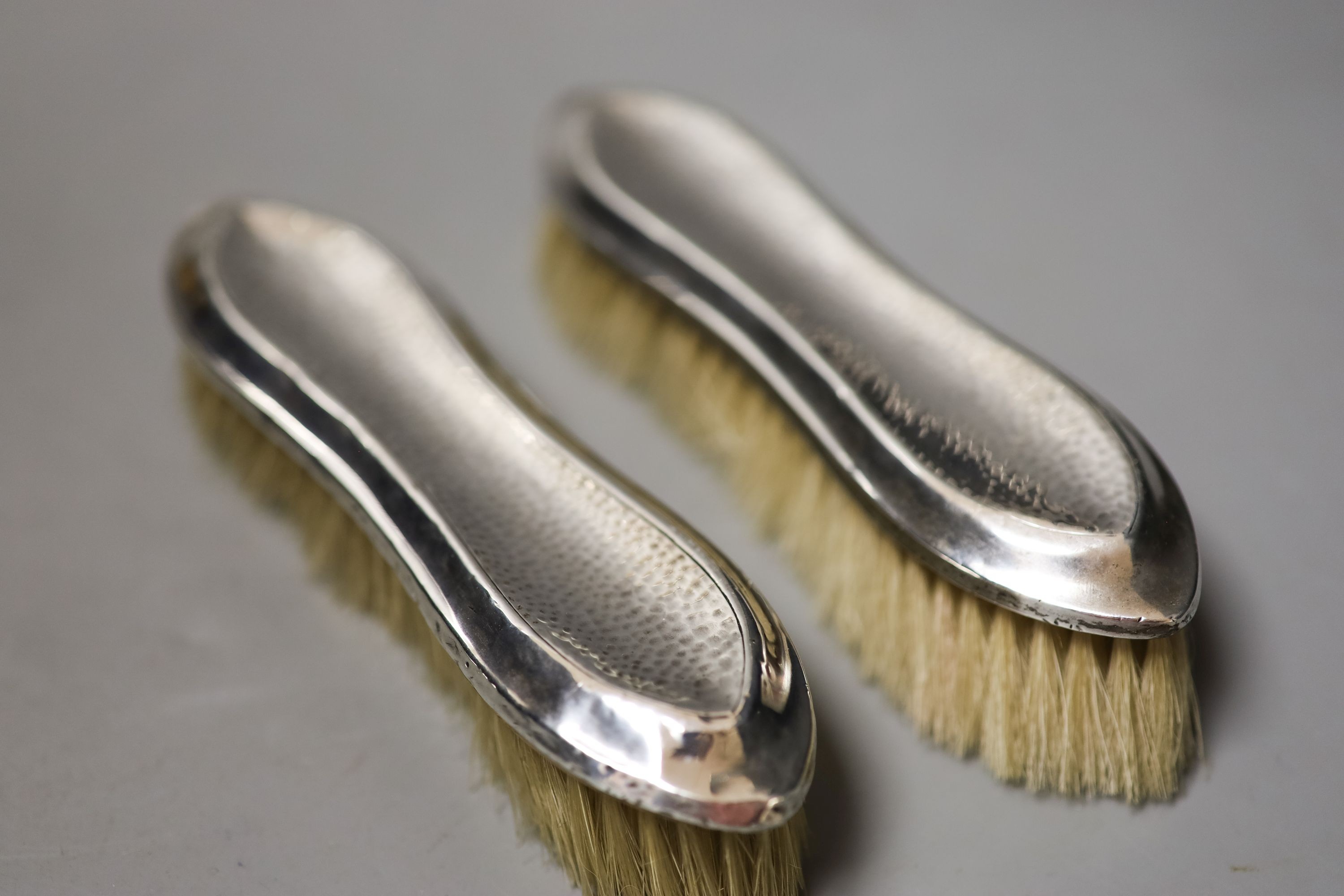 An Edwardian matched part planished silver five piece mirror and brush set, Saunders & Shepherd, Birmingham, 1907/8(4) and Chester, 1908.